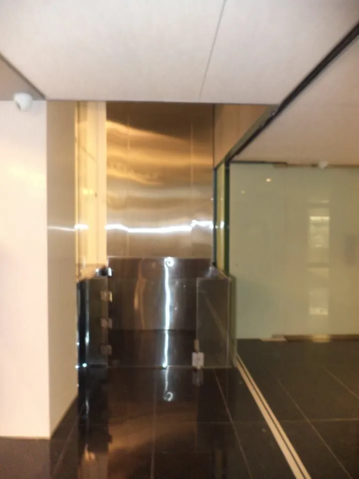 Hall de ascensor con acabados en tono bronce